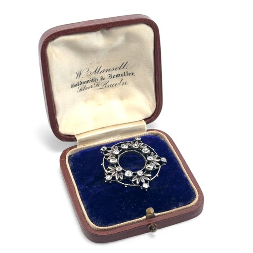 14 - A Victorian diamond brooch in a silver on gold open work mount, set with cushion shaped old cut diam... 