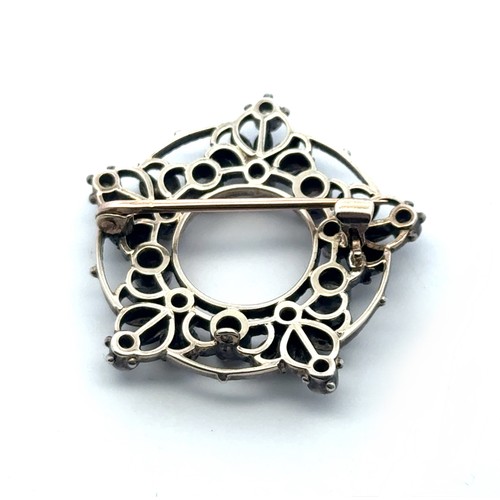 14 - A Victorian diamond brooch in a silver on gold open work mount, set with cushion shaped old cut diam... 