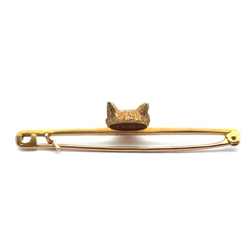 29 - A gold fox head bar brooch with red stone eyes, length 50mm. Pin and bar stamped 9ct, fox head tests... 