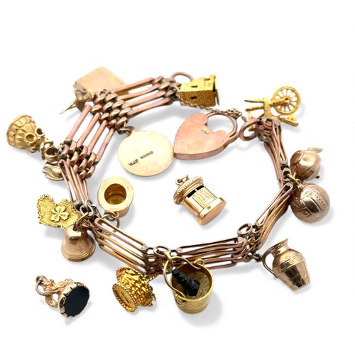39 - Gold gate link charm bracelet with 15 attached charms and two additional charms.