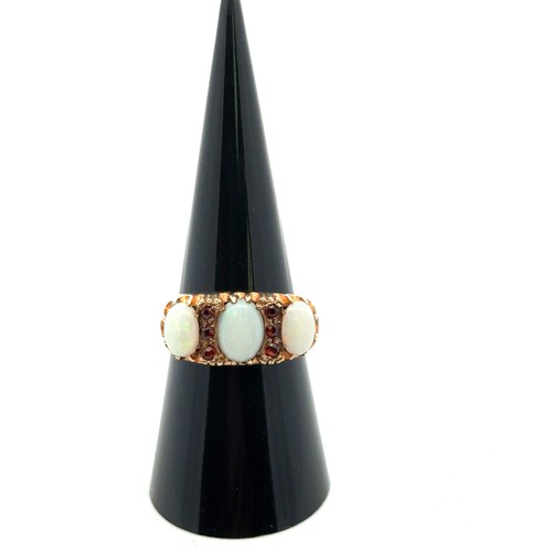 25 - A 9ct gold, opal and garnet ring, size O.
