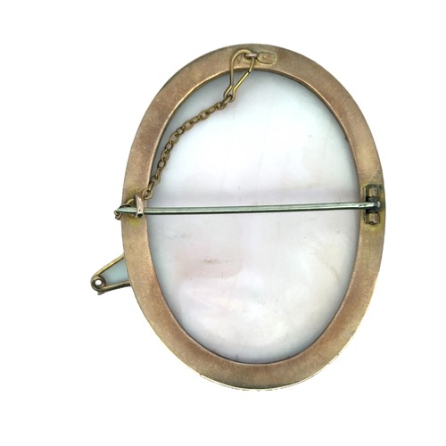 23 - A pink and white shell cameo brooch depicting a Greek or Roman female in a yellow metal mount stampe... 