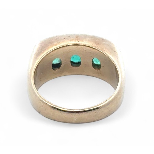 3 - A three stone emerald ring with diamond, size M. Emeralds each approx 6mm x 5mm. Unmarked yellow met... 