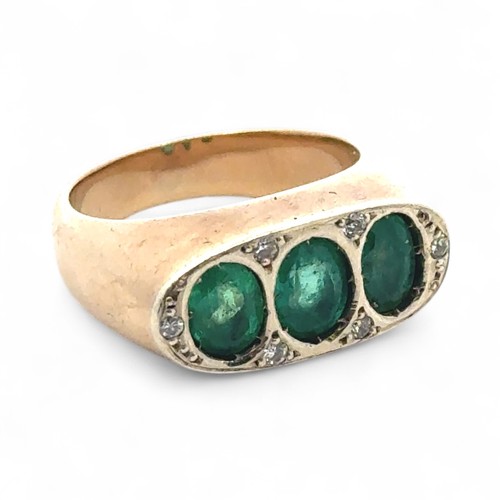 3 - A three stone emerald ring with diamond, size M. Emeralds each approx 6mm x 5mm. Unmarked yellow met... 