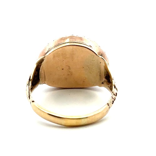7 - A Georgian ring with a rock crytsal and yellow foil back central oval panel surrounded by a halo of ... 