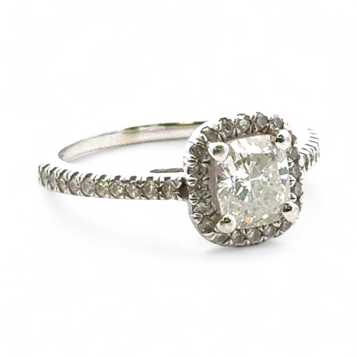 51A - A 0.71ct cushion cut diamond halo ring with diamond set shoulders, size I. Total diamond weight 0.93... 