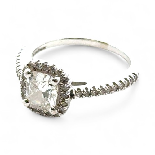 51A - A 0.71ct cushion cut diamond halo ring with diamond set shoulders, size I. Total diamond weight 0.93... 