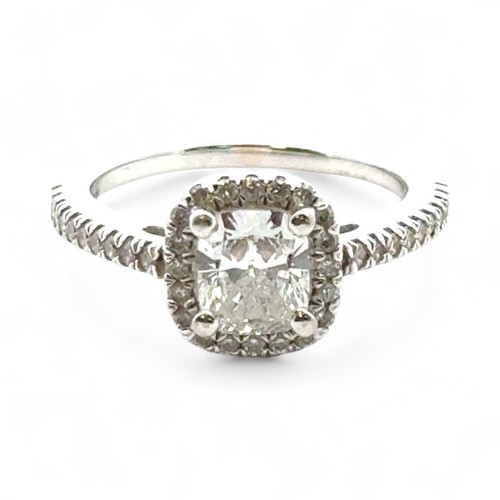 51A - A 0.71ct cushion cut diamond halo ring with diamond set shoulders, size I. Total diamond weight 0.93... 