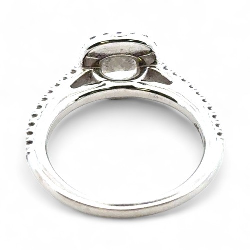 51A - A 0.71ct cushion cut diamond halo ring with diamond set shoulders, size I. Total diamond weight 0.93... 