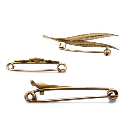 51 - Three gold brooches. A 9ct gold leaf brooch, a seed pearl flower brooch, and a pheasant tie pin.