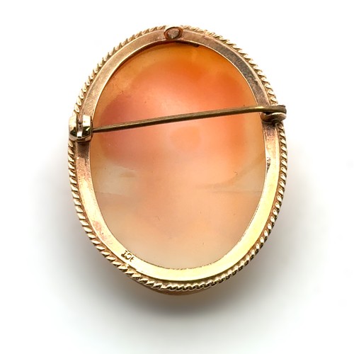 21 - A shell cameo brooch depicting a lady in profile, in yellow metal mount with rope twist edge, stampe... 