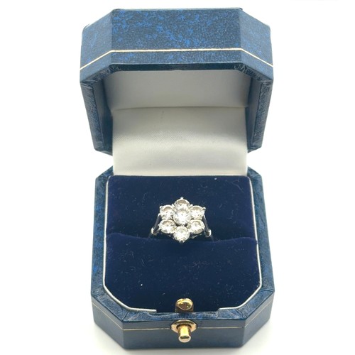 9 - A diamond cluster flower ring in a white metal mount stamped 18ct and platinum. Size P. Total estima... 