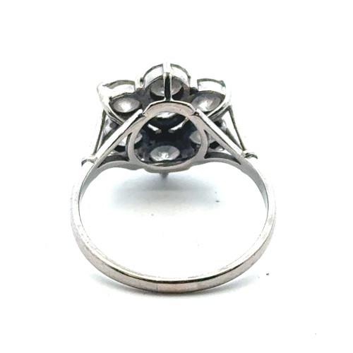 9 - A diamond cluster flower ring in a white metal mount stamped 18ct and platinum. Size P. Total estima... 