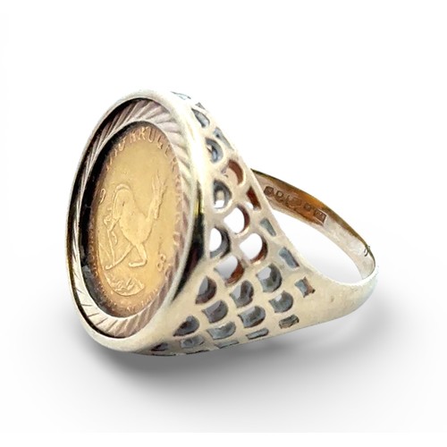5 - A 1/10 Krugerand (1986) signet ring set in a 9ct yellow gold mount with pierced shoulders. Size M wi... 