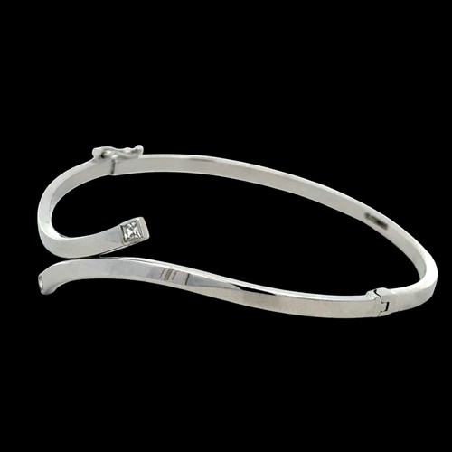 74 - 9ct white gold twist bangle, both ends set with a princess cut  white stone, width 65mm