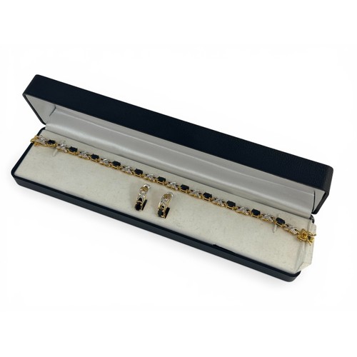 73 - A gold plated sapphire and white stone bracelet with matching half hoop earrings. Bracelet length ap... 