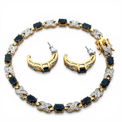 73 - A gold plated sapphire and white stone bracelet with matching half hoop earrings. Bracelet length ap... 