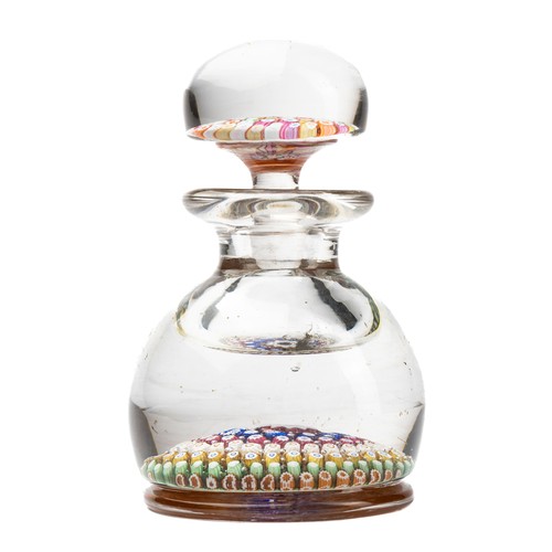 639 - A glass paperweight-inkwell, the heavy glass base inset millefiori colourful canes, the base with wo... 