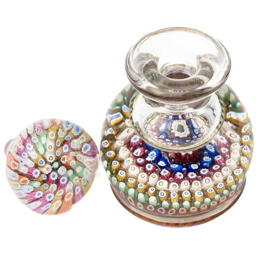 639 - A glass paperweight-inkwell, the heavy glass base inset millefiori colourful canes, the base with wo... 