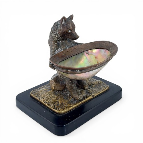 650 - An early 20th Century bronze table salt in the form of a Black Forest bear. The bear seated on a log... 