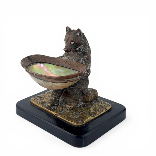 650 - An early 20th Century bronze table salt in the form of a Black Forest bear. The bear seated on a log... 