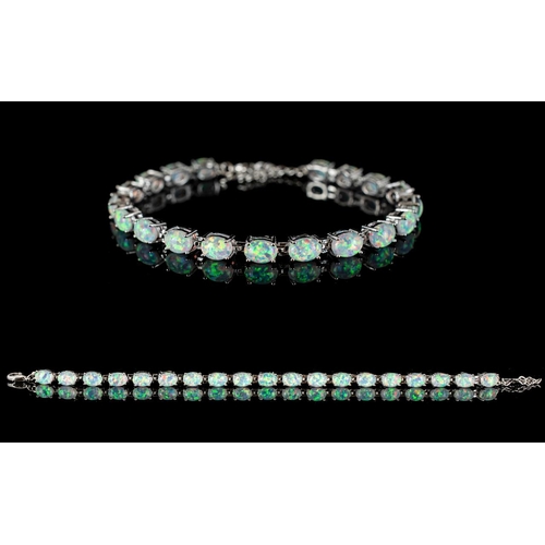 368 - A Silver And Opal Style Set Tennis Bracelet - Comprising 19 Opal Style Stones. Of Iridescent Lustre,... 