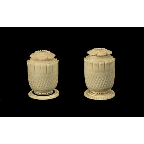 842 - Pair of Anglo Indian Carved Ivory Pepperettes, c1860s, with screw petal shaped lids, on a round pede... 