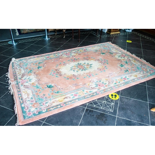 1026 - A Chinese Wool Rug 100% Wool. Peach ground with fringed edges, centre circular cream relief.  Measur... 