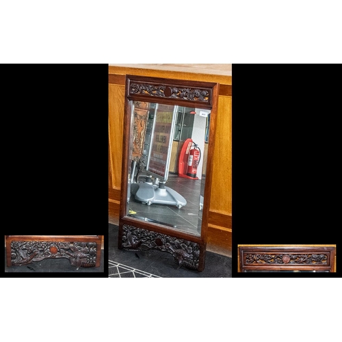 817 - Chinese Rosewood Carved Wall Mirror, depicting birds amongst foliage to the frame borders; with a be... 