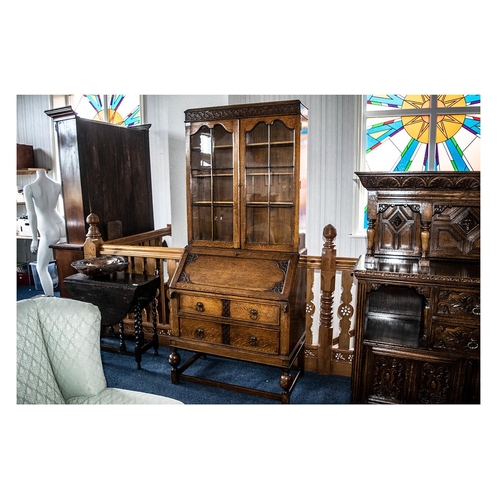 1072 - 1930s Oak Jocobean Style Bureau Bookcase with a glazed top, the bureau with a fitted interior with a... 