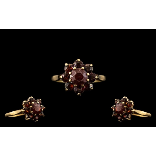 168 - 9ct Gold Garnet Set Ring, with a flower head design.  Ring Size L.