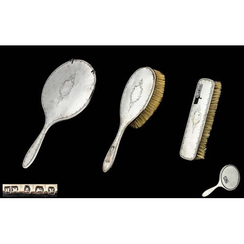 94 - Ladies Silver Three Piece Vanity Set comprising a hand mirror, hair brush and clothes brush, hallmar... 