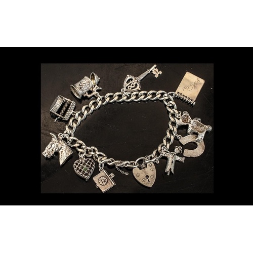 150 - A Silver Charm Bracelet with padlock fastener with ten charms. Gross weight 52 grams.