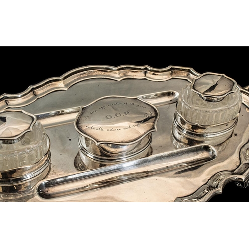 132 - A Large Silver Twin Handled Desk Tidy of scalloped molded form with 2 wells, a pair of ink wells and... 