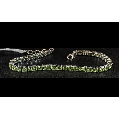 190 - Peridot Tennis Bracelet, round cut, sparkling peridots, totalling 10cts, closely set in a single lin... 