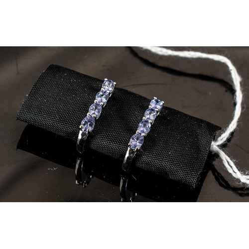 126 - Tanzanite Hinged J-Hoop Earrings, each having four oval cut, bright blue tanzanites, closely set, do... 