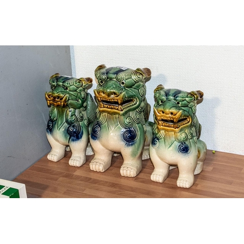 642 - Three Oriental Foo Dogs, one 10'' tall and a pair 9'' tall.