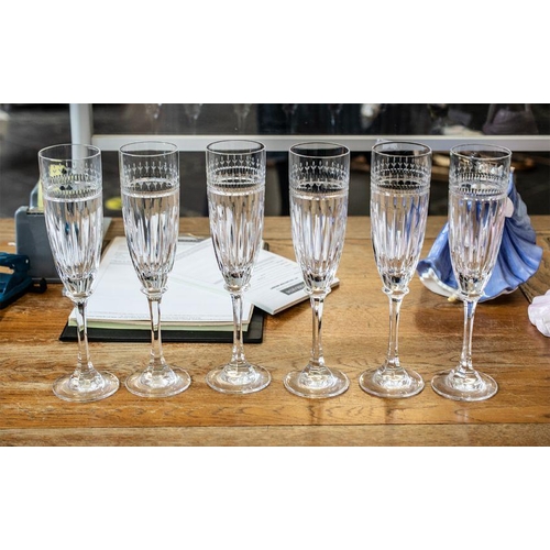 752 - Six Tall Glass Champagne Flutes, with floral etching to top and star cut glass bowl, raised on a tal... 