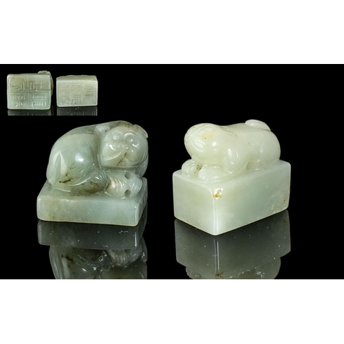 806 - A Pair of Two Jade Seals both surmounted by stylised beasts with Archaic script to base.