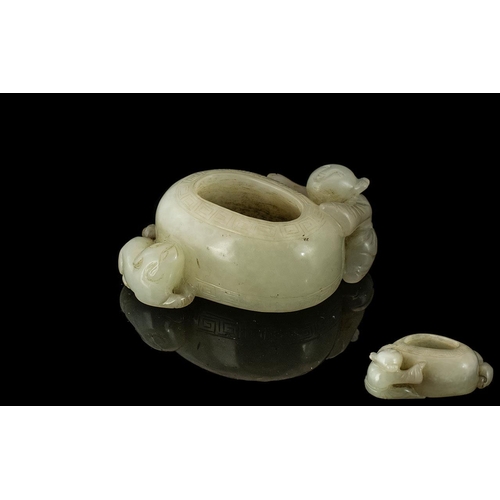 857 - A Brush Pot in White Jade depicting a boy climbing on side. Measures 2 inches wide.