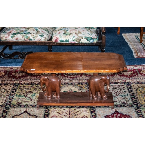 1029 - A Early 20th Century Coffee Table Shaped Rectangular Top Raised On Carved Elephant Supports With Pla... 