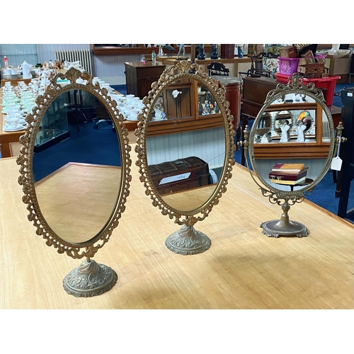 1039 - Three Brass Continental Style Toilet/Hall Table Mirrors. Approx height 22''.