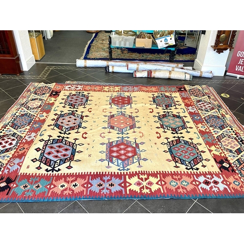 1054 - An Aztec Design Woolen Rug, Beige Ground, Bright Geometric Decoration, 360 x 275cm.