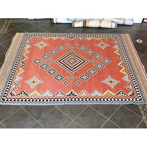 1056 - An Aztec Design Woolen Rug, Salmon Ground, Bright Geometric Decoration, 310 x 250 cm.