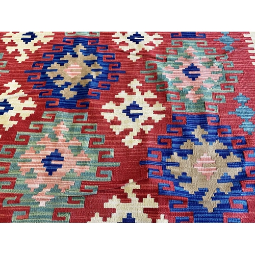 1057 - An Aztec Design Woolen Rug, Red Ground, Bright Geometric Decoration, 220 x 190 cm.