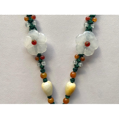 449 - Two Green Jade Pendant Necklaces, one having a large, carved, floral pendant, on a thread necklace d... 