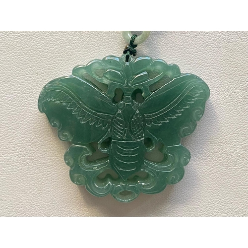 449 - Two Green Jade Pendant Necklaces, one having a large, carved, floral pendant, on a thread necklace d... 