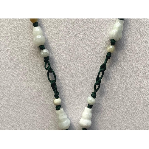 449 - Two Green Jade Pendant Necklaces, one having a large, carved, floral pendant, on a thread necklace d... 