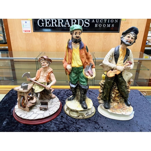 617 - Three Capo di Monte Figures, comprising a man sharpening tools, a violin player and a fish seller, s... 