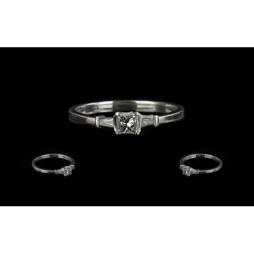 311 - 18ct Gold Princess Cut Single Stone Diamond Ring with tapered Baguette cut shoulders. Ring size P.